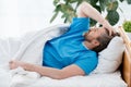 patient in medical gown lying and touching head in hospital.