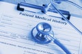 Patient medical history on a clipboard with stethoscope and a blue ballpoint pen. Royalty Free Stock Photo