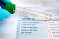 Doctor holding tube with nasal swab and requisition form for analysis of Covid-19 or coronavirus test Royalty Free Stock Photo