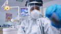 Patient pov of dentist holding dental tools wearing covid protection suit