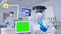 Patient pov of dentist in ppe suit pointing on green screen