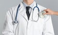 Patient putting bribe into doctor`s pocket on background, closeup. Corruption in medicine Royalty Free Stock Photo