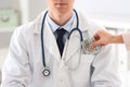 Patient putting bribe into doctor`s pocket in clinic. Corrupted medicine Royalty Free Stock Photo