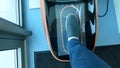 Patient putting leg in automatic shoe cover dispenser, hygiene and sterility