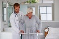 Patient recovery comes first. a senior woman walking carefully with help from her doctor and an orthopedic walker. Royalty Free Stock Photo