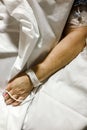 Patient`s arm on a bed sheet in hospital