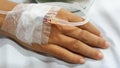 Patient with saline drip bag on bed in hospital
