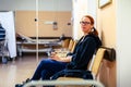Patient sitting in hospital ward hallway waiting room with iv. Royalty Free Stock Photo