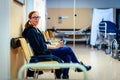 Patient sitting in hospital ward hallway waiting room with iv. Royalty Free Stock Photo