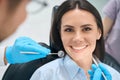 Patient sitting in orthodontic chair and waiting qualified dentist examining her teeth