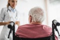 Patient sitting in wheelchair and looking at doctor Royalty Free Stock Photo