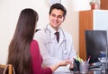 Patient and therapeutist at desk in clinic. Royalty Free Stock Photo