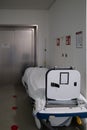 Patient transport bed stands in front of an elevator in a hospital