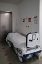 Patient transport bed stands in front of an elevator in a hospital