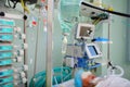 Patient under IV drip in an intensive care unit, connected to life-support devices