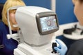 Patient during visit to optometrist for microscopic analysis of eyelids, sclera, conjunctiva, iris, lens, cornea. Examining of