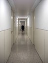 Patient walking alone in a hospital hallway Royalty Free Stock Photo