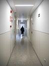 Patient walking alone in a hospital hallway Royalty Free Stock Photo