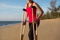 Patient woman using crutches support broken legs for walking beach,Physical therapy concept