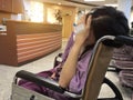 Patient woman on wheelchair in hospital, feeling sick with migraines Royalty Free Stock Photo