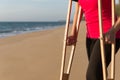 Patient woman using crutches support broken legs for walking beach,Physical therapy concept,Close up