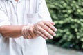 Patients elderly wrist pain hands, due to a nervous system illness and paralysis