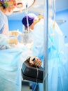 Patients hand with a sensor on the blurry background of the group of doctors in the operating room. Close up Royalty Free Stock Photo