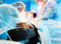 Patients hand with a sensor on the blurry background of the group of doctors in the operating room. Close up Royalty Free Stock Photo