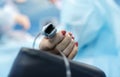 Patients hand with a sensor on the blurry background of the group of doctors in the operating room. Close up Royalty Free Stock Photo