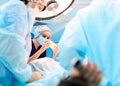 Patients hand with a sensor on the blurry background of the group of doctors in the operating room. Close up Royalty Free Stock Photo