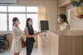 Patients wearing face mask contact for treatment sickness with receptionist at reception in hospital