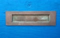 Patina Brass Mail Slot in Distressed Blue Wooden Door
