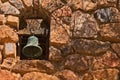 A patinated mission bell set in an old stone wall. Royalty Free Stock Photo