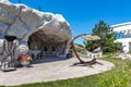 Patio area equipped in artificial rocky cave in green backyard on country estate