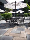 Patio courtyard with table, chairs and white umbrellas Royalty Free Stock Photo