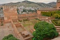 Patio and fortified walls of Alhambra castle, Granada, with mountains behind