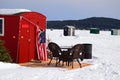 Patio furniture outside an ice fishing shack on a frozen lake Royalty Free Stock Photo