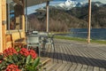 Patio restaurant outside porch space empty table without people flowers foreground with scenic picturesque background view on Alps