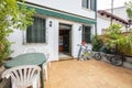 Patio of single family home with green resin table and white chairs,