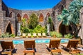 Patio with swimming pool surrounded by sun loungers Royalty Free Stock Photo