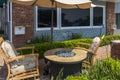 a patio with wooden chairs and a round table and a umbrella surrounded by lush green trees and plants in Long Beach California Royalty Free Stock Photo