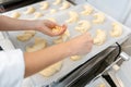 Patissier in her bakery putting croissant dough pieces on a tray