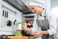 Patissier putting cocoa powder on little cakes