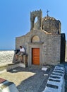 Male tourist reads a book in front of chapel