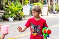 Patong, Phuket, Thailand - Songkran Festival. Blonde young boy with a water cannon