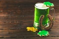 Patrick`s day background with a Glass of green beer and clover gingerbread with gold coins on wooden Royalty Free Stock Photo