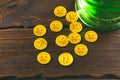 Patrick`s day background with a Glass of green beer and clover gingerbread with gold coins on wooden Royalty Free Stock Photo