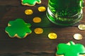 Patrick`s day background with a Glass of green beer and clover gingerbread with gold coins on wooden Royalty Free Stock Photo