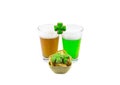 Patrick`s Day glasses of a foamy drink amber and green beer with a snack and clover on a white