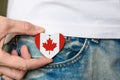 Patriot of Canada! Wooden badge with the flag of Canada in the shape of a heart in a man`s hand